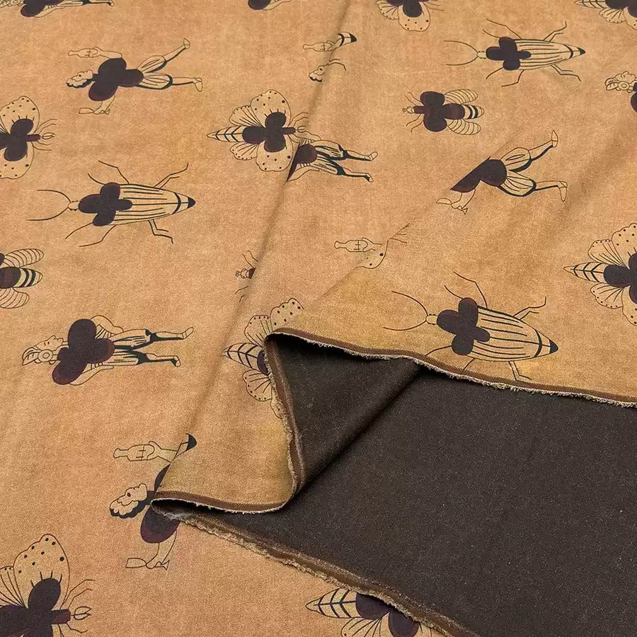 a close-up view of a fabric with a repeating pattern of stylized insects or bugs printed on it. The pattern is predominantly brown, with some black accents. The insects appear to be in various poses and orientations, creating a dynamic and visually interesting design.