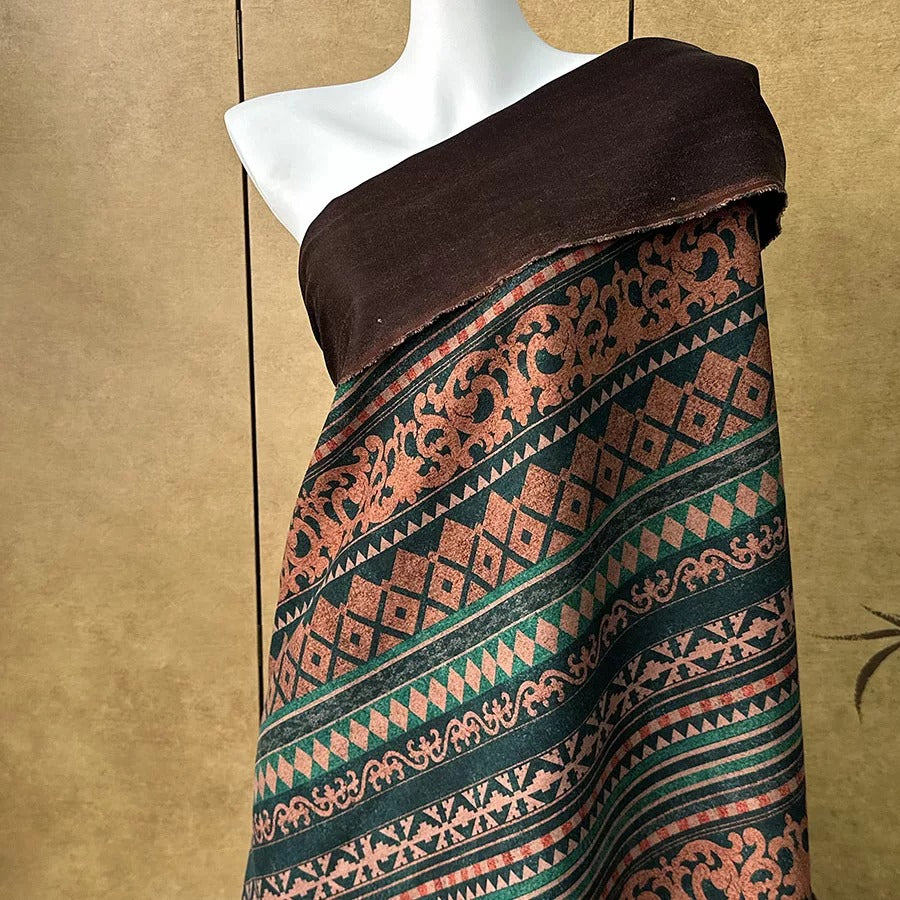 A mannequin wearing a brown and green patterned dress with a black top.