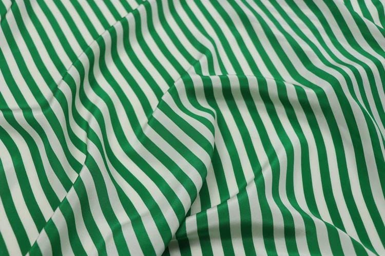 a close-up view of a fabric with green and white striped patterns.