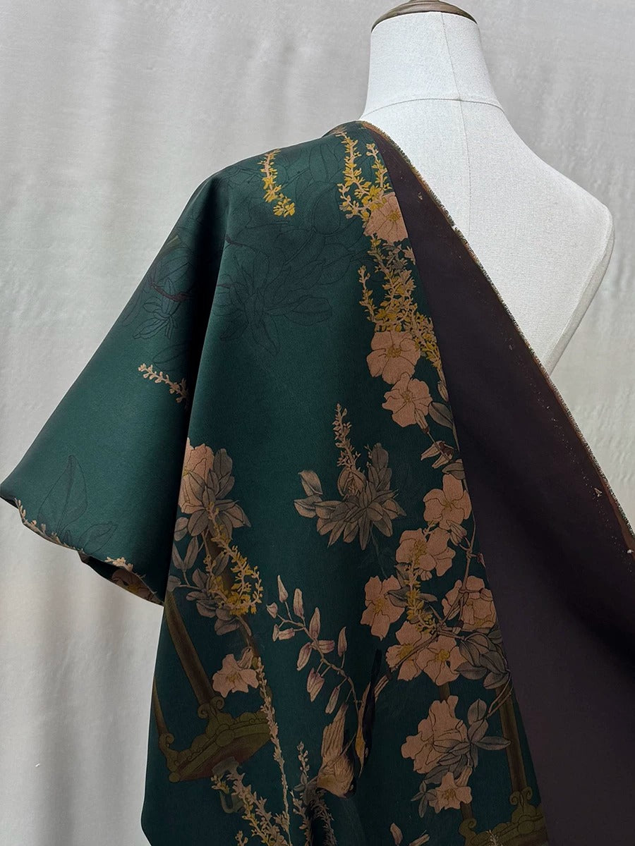 A mannequin wearing a green and brown floral print dress with a dark brown overlay.