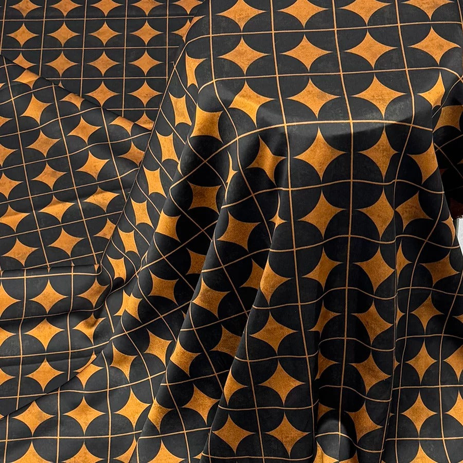 a close-up view of a fabric with a repeating pattern of black and orange geometric shapes, creating a visually striking and intricate design.
