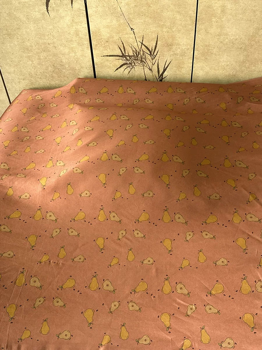 a bed with a pink and yellow patterned bedspread, featuring a repeating pattern of small yellow birds on the fabric.
