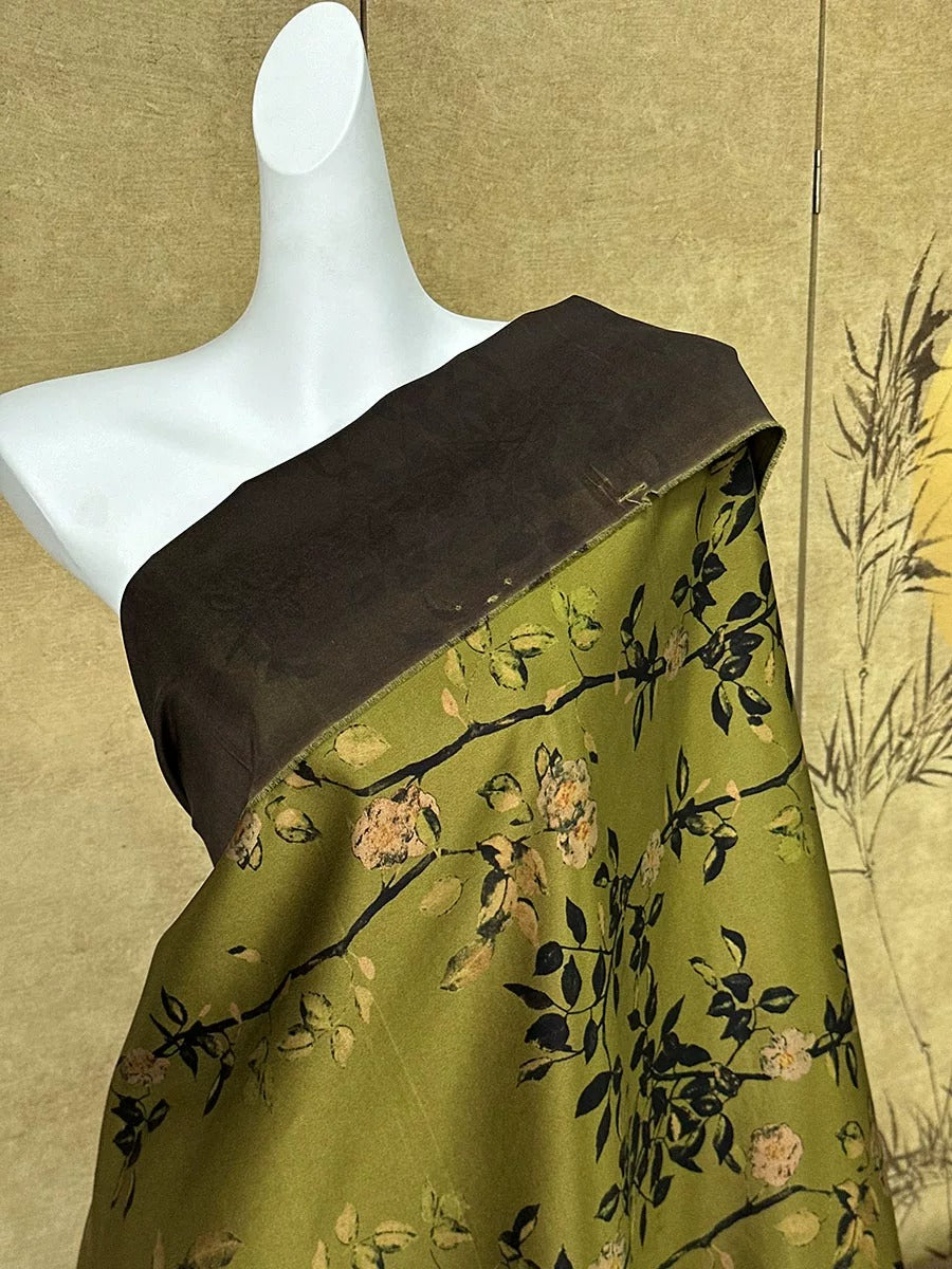 A mannequin wearing a green and brown floral print dress with a brown top.