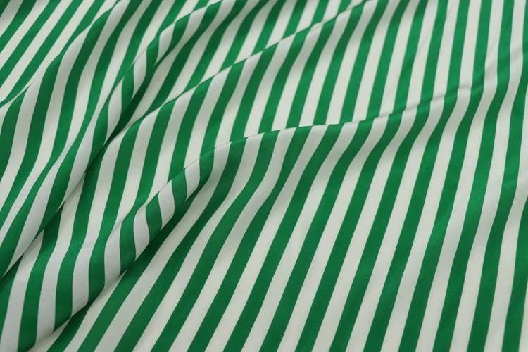 a close-up view of a fabric with a repeating pattern of green and white stripes.