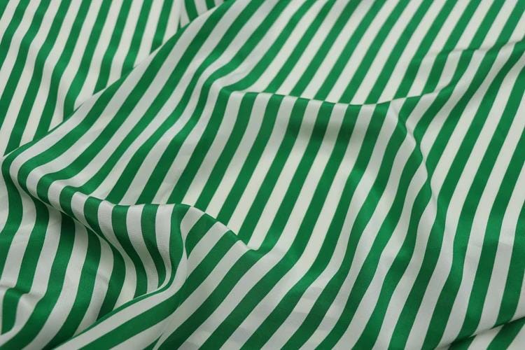 a close-up view of a fabric with a repeating pattern of green and white stripes.