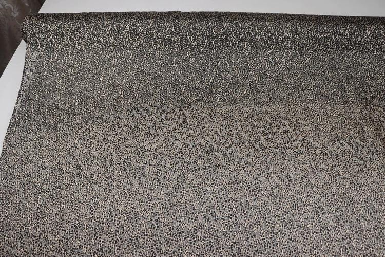 a close-up view of a textured fabric with a speckled or speckled pattern.