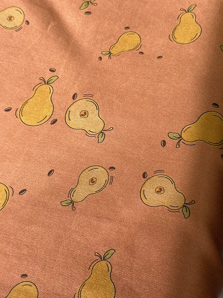 a close-up view of a fabric with a repeating pattern of yellow pear illustrations.