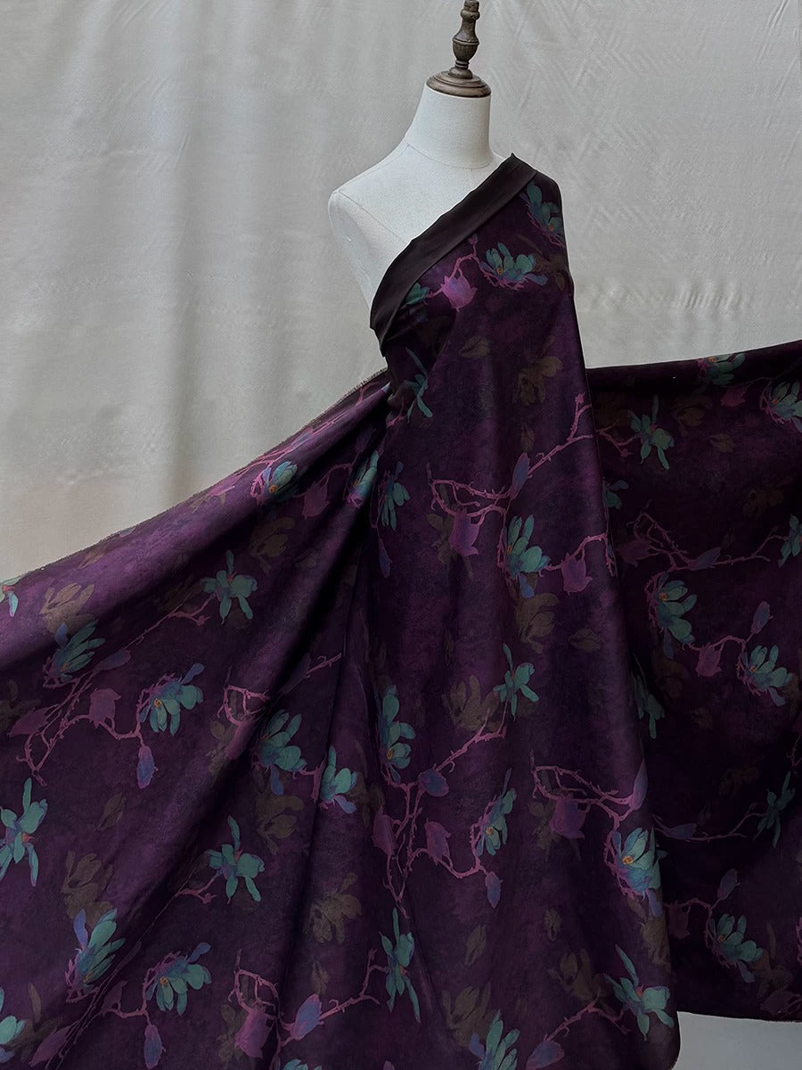 A mannequin wearing a long, flowing purple dress with a floral pattern.