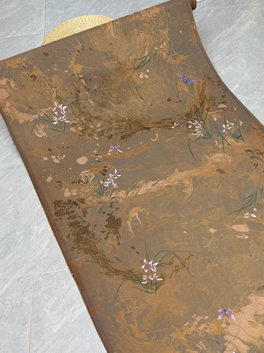 a brown and gold marble-like surface with delicate pink and white flowers scattered across it.