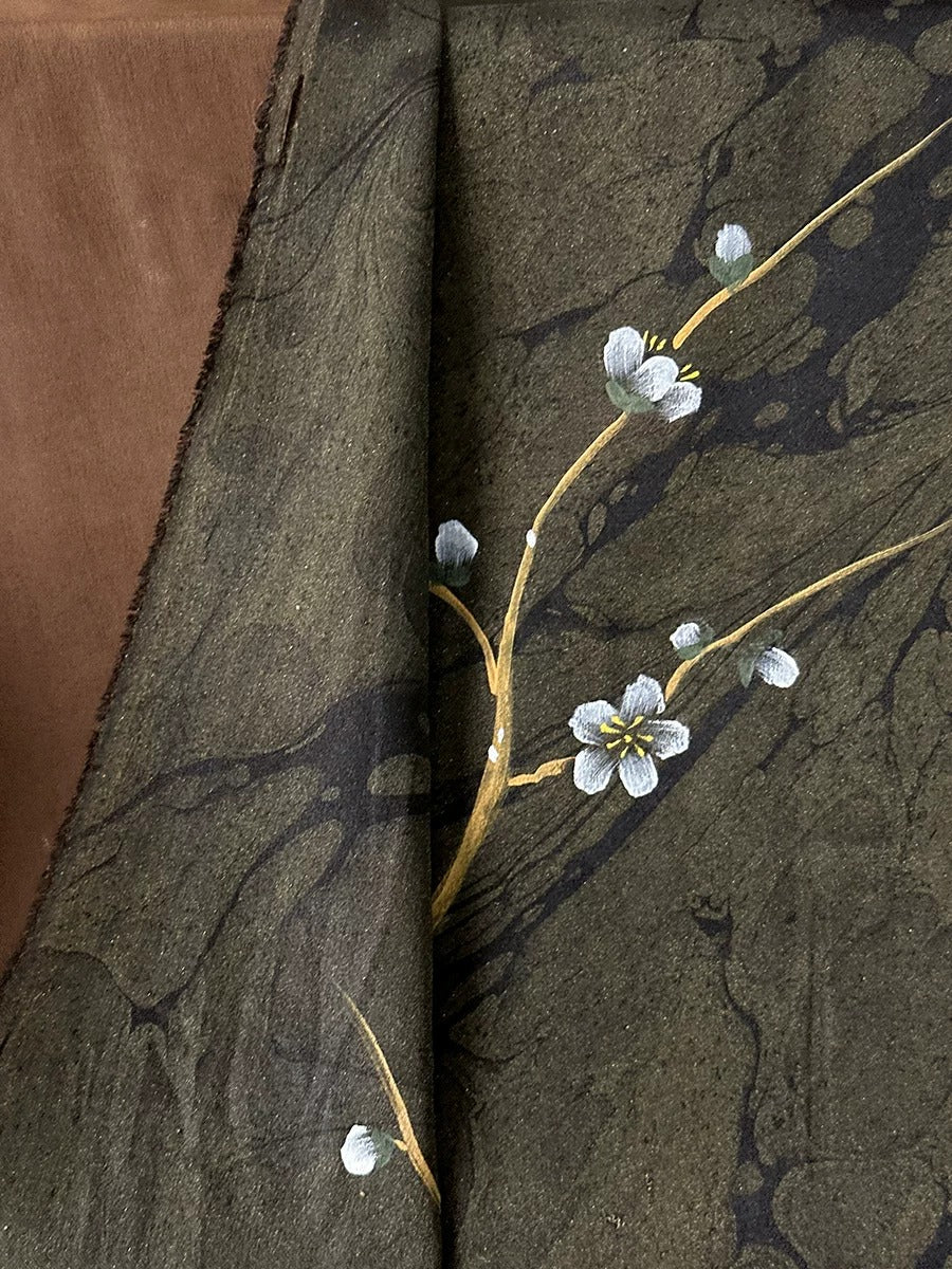 a close-up view of a dark green fabric with a delicate white flower design on it.