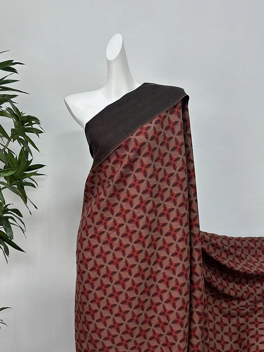 A mannequin wearing a red and black patterned dress with a black top, displayed against a white background.