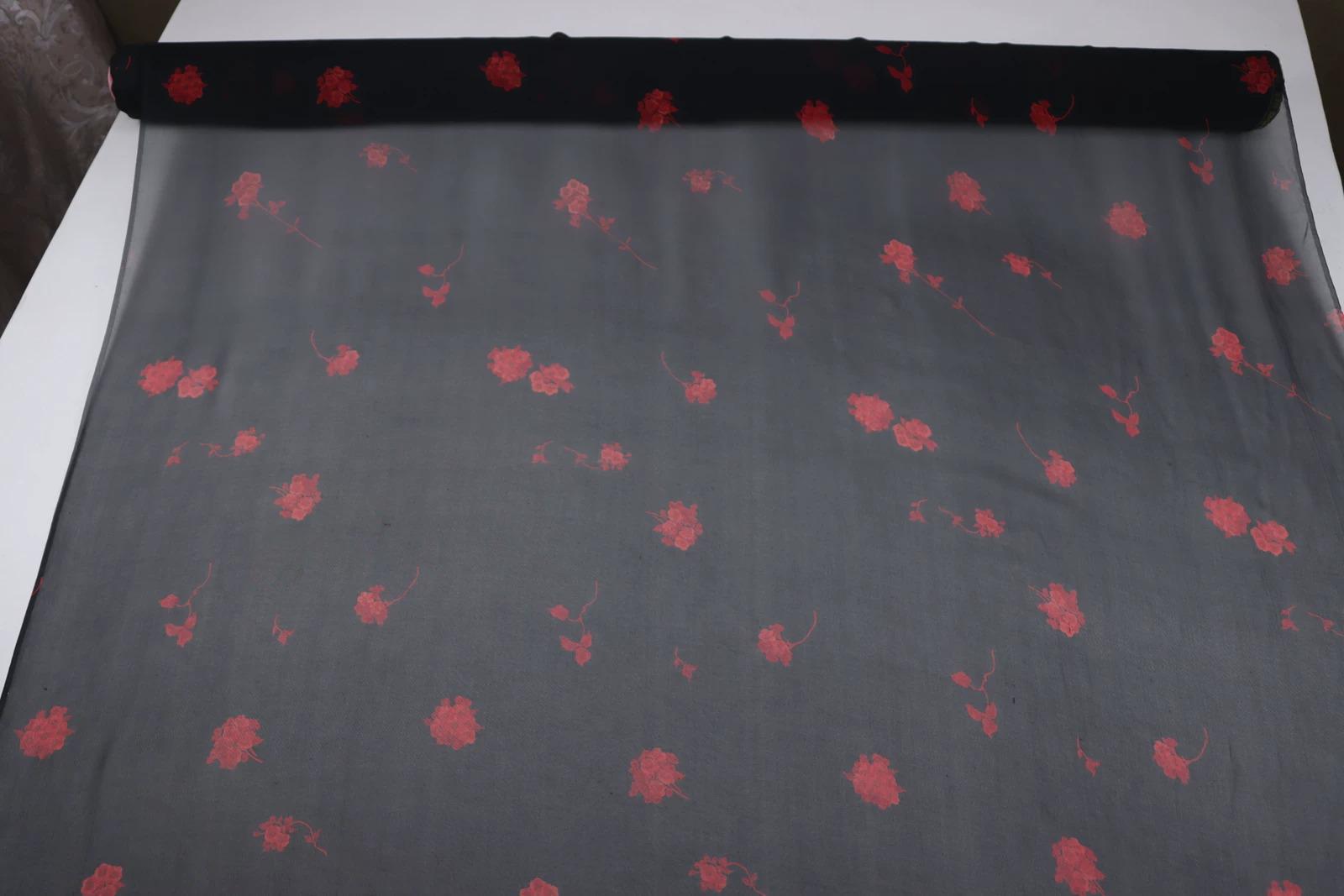a black fabric with red floral patterns on it.