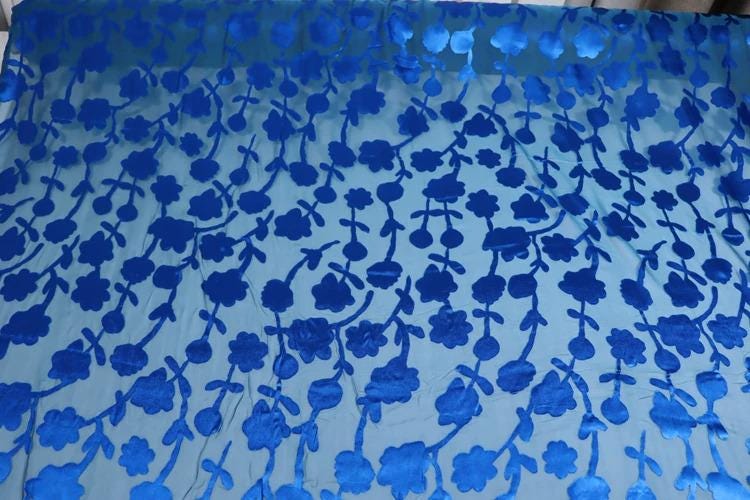 a fabric with a repeating pattern of blue flowers and leaves.