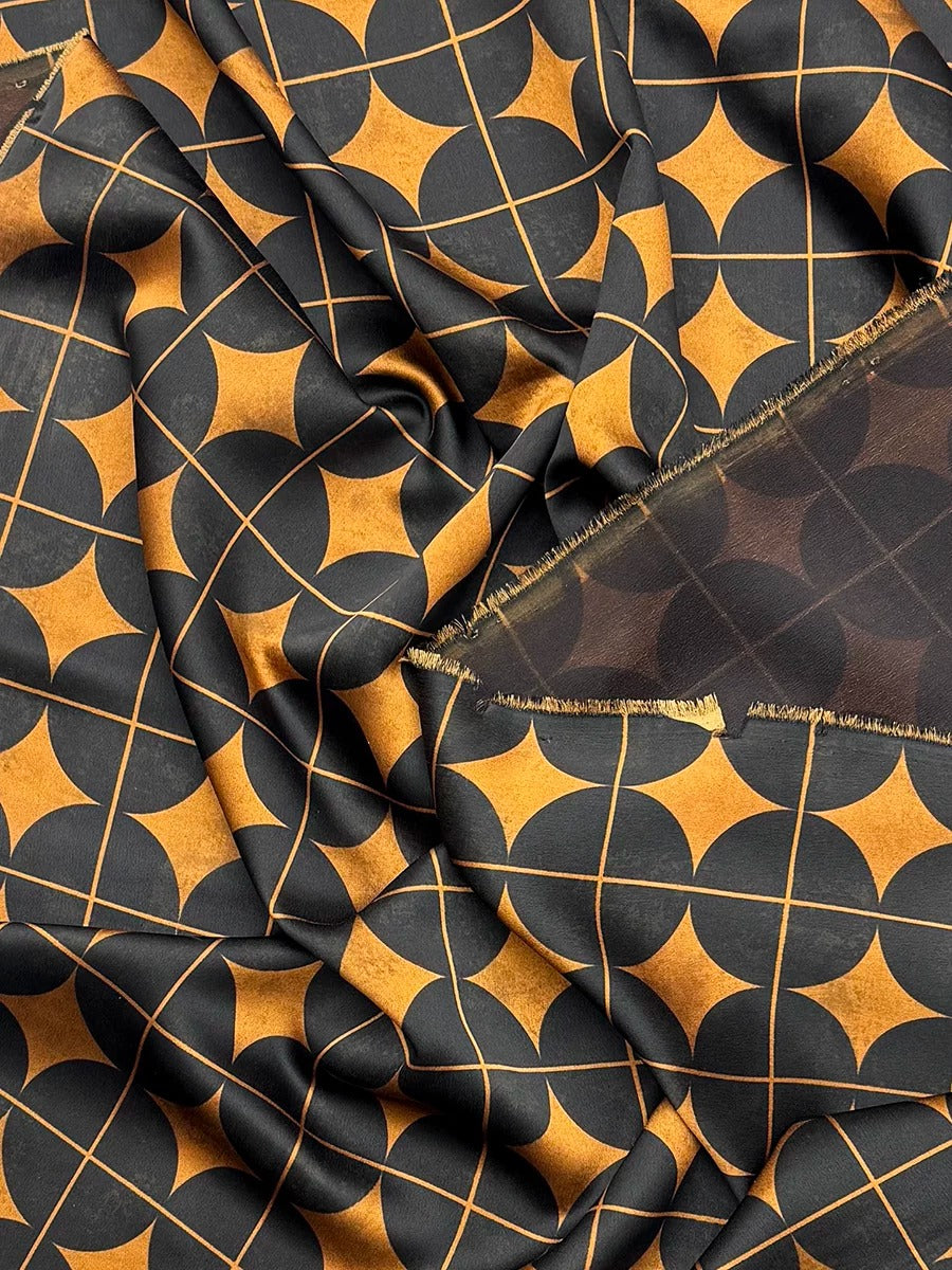 a close-up view of a fabric with a repeating pattern of black and gold geometric shapes, creating a visually striking and intricate design.