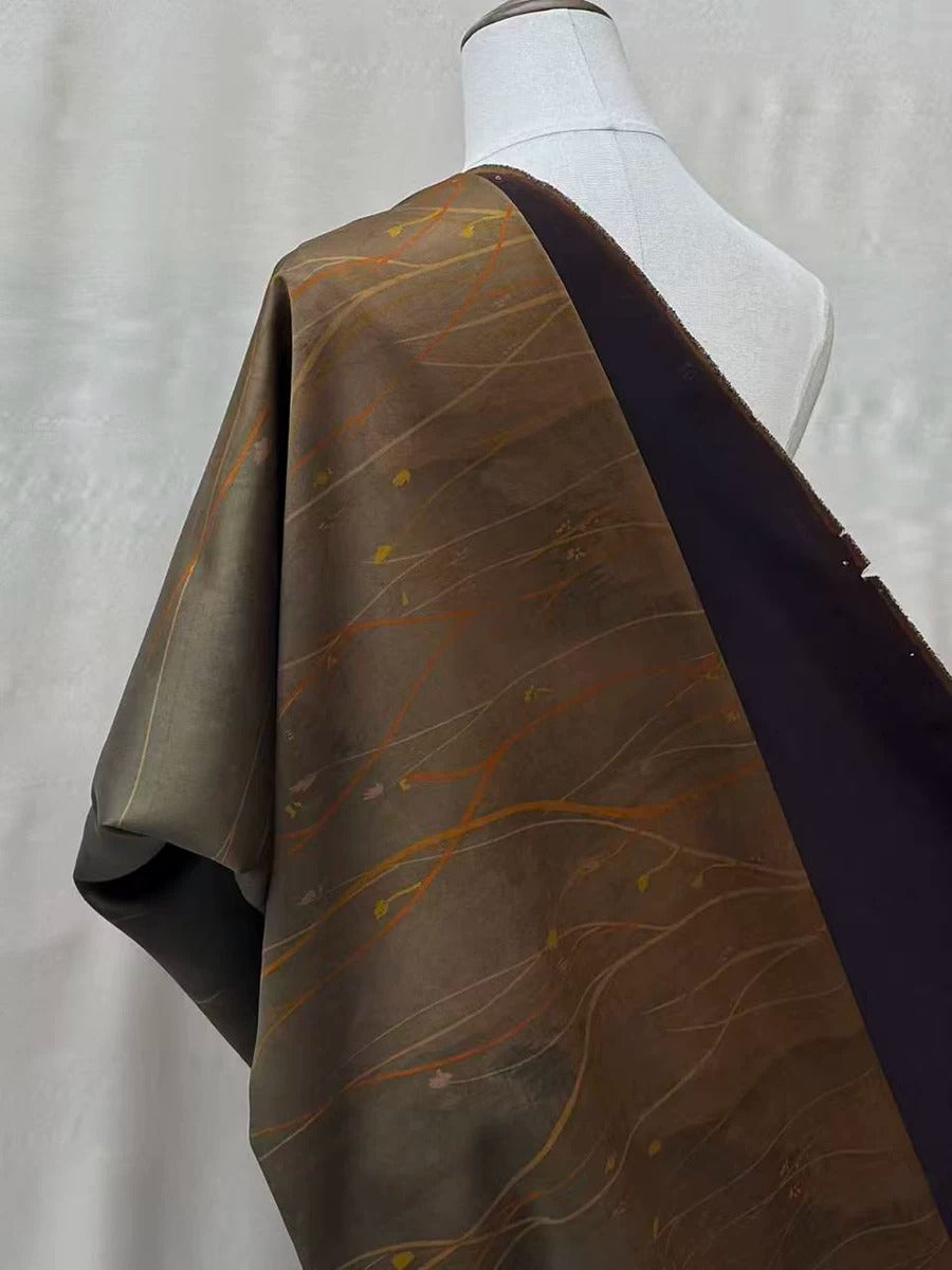 a mannequin wearing a brown and black patterned fabric draped over its torso.