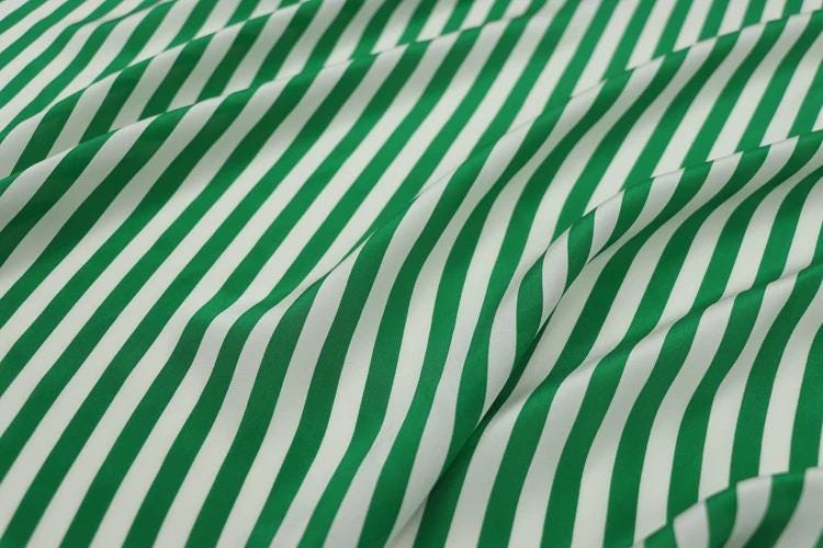 a close-up view of a fabric with green and white striped patterns.