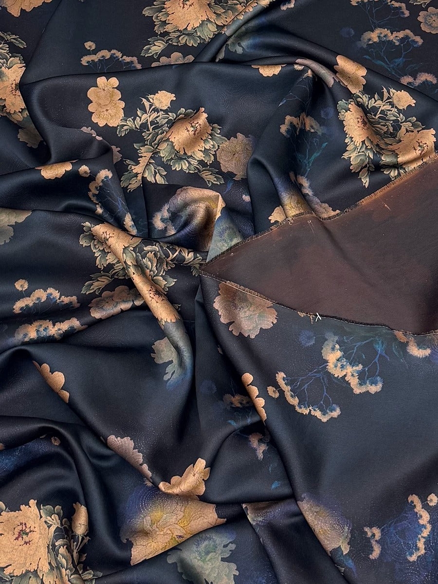 a close-up view of a fabric with a floral pattern in shades of blue and gold. The fabric appears to be crumpled and wrinkled, giving it a textured and somewhat messy appearance.