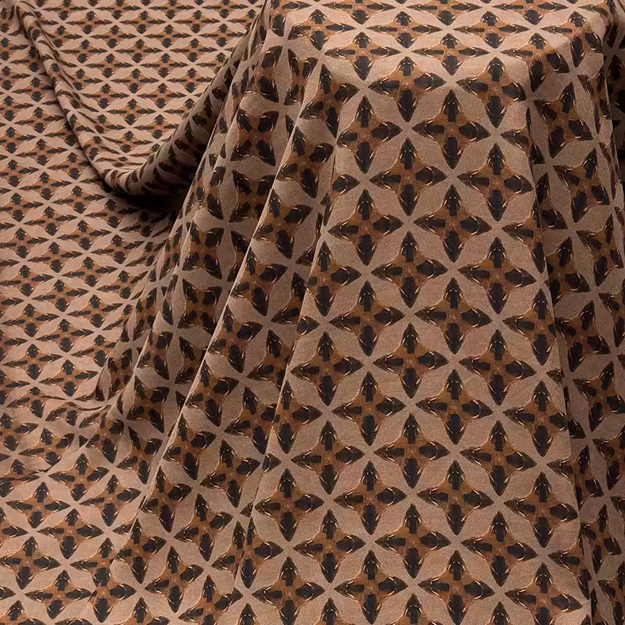 a fabric with a repeating pattern of brown and black geometric shapes, creating a visually striking and intricate design.
