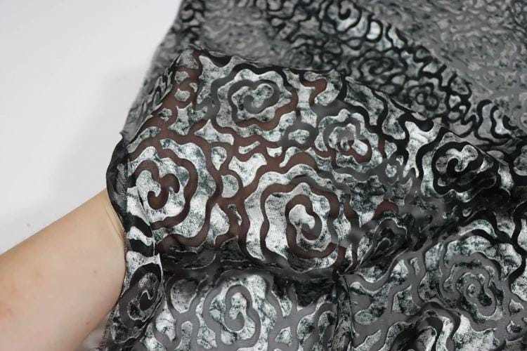 a close-up view of a fabric with a black and white floral pattern.