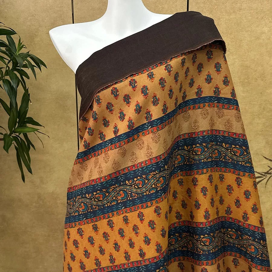 A mannequin wearing a colorful, patterned fabric draped over its shoulders.