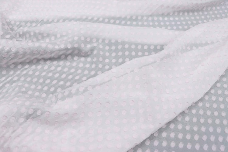 a close-up view of a fabric with a white polka dot pattern.
