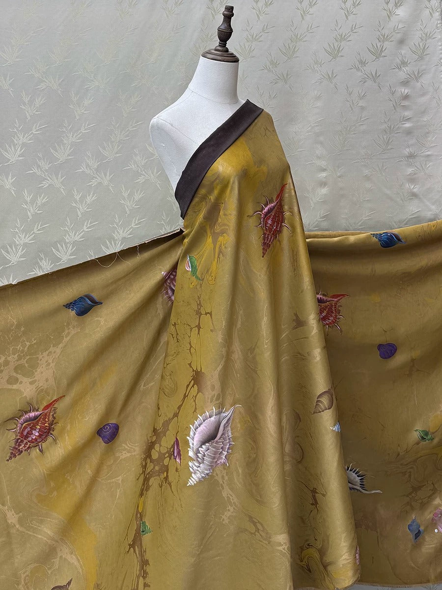 A mannequin wearing a gold and brown printed dress with various colorful designs, including seashells and flowers, against a white background.