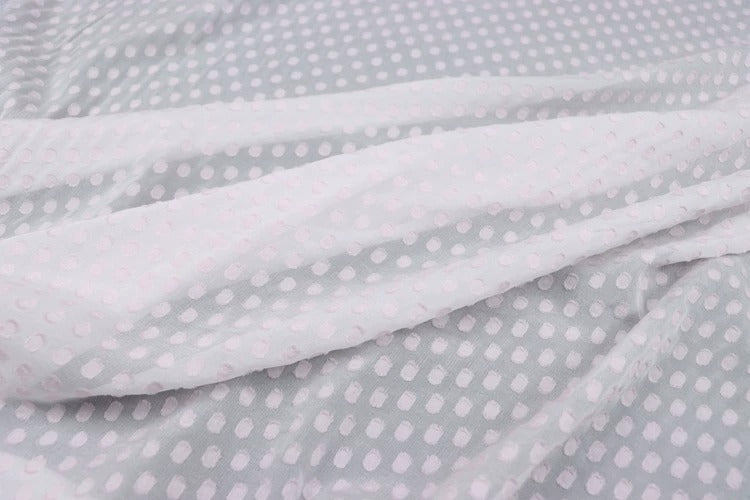 a close-up view of a fabric with a white polka dot pattern.