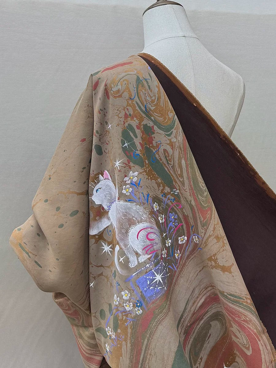 A mannequin wearing a colorful, patterned fabric with a cat design on it.