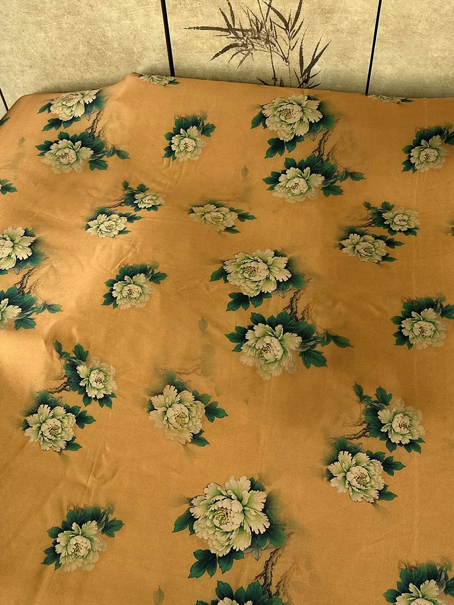 a close-up view of a fabric with a floral pattern, featuring white and green flowers arranged in a repeating pattern.