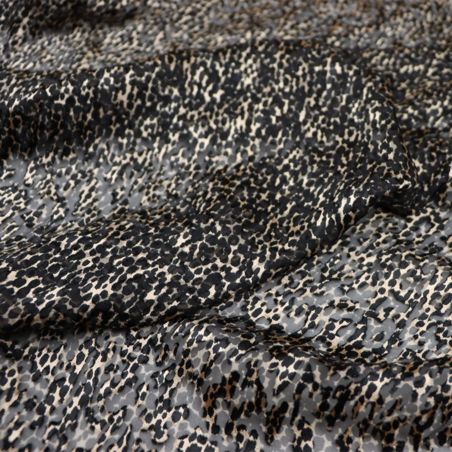 a close-up view of a fabric with a distinctive black and white spotted pattern.