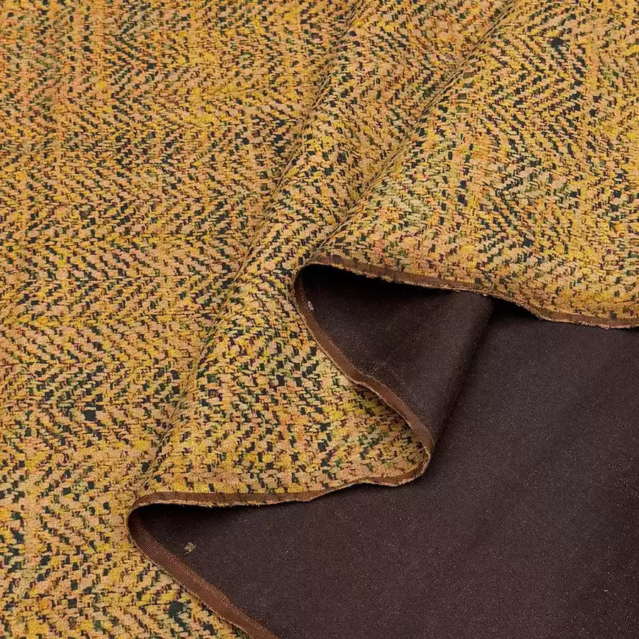 a close-up view of a fabric with a yellow and black zigzag pattern. The fabric appears to be a blend of two different colors, with the yellow fabric being more prominent and the black fabric partially visible underneath.