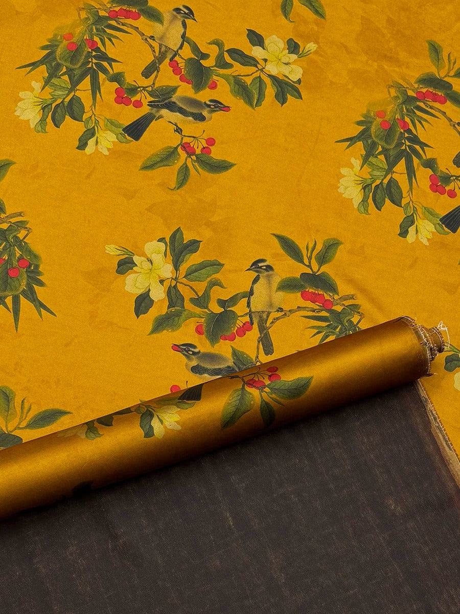 a vibrant yellow fabric with a repeating pattern of green leaves, yellow flowers, and red berries. The fabric appears to be rolled up and placed on a dark surface, creating a visually striking contrast.