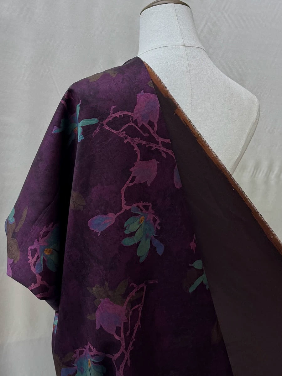a mannequin wearing a purple fabric with a floral pattern.