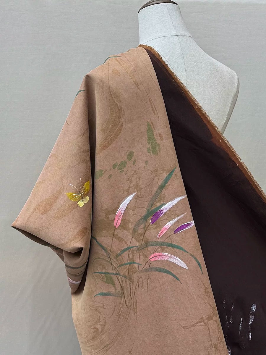 A mannequin wearing a brown and black patterned fabric with a butterfly design.