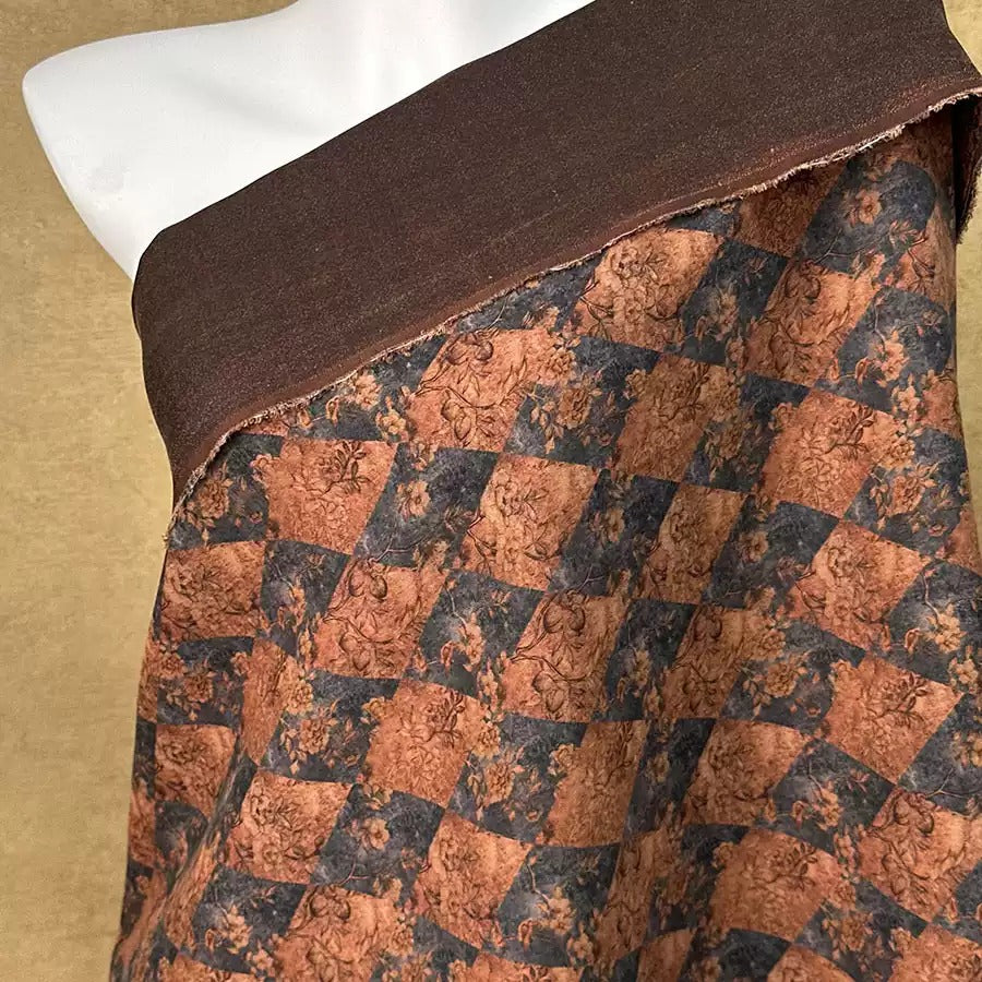 a mannequin wearing a brown and black patterned fabric.