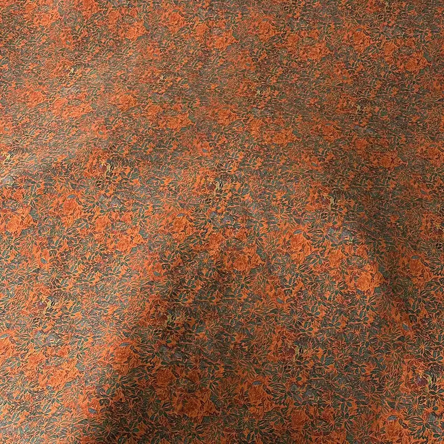 a textured surface with a pattern of orange and brown colors, resembling a carpet or a fabric with a floral design.
