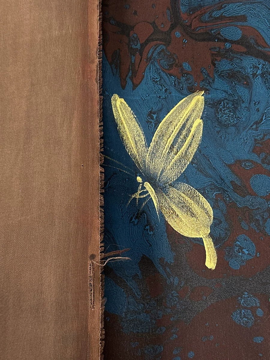 a close-up view of a butterfly painted on a textured surface, with a brown wooden border on the left side.