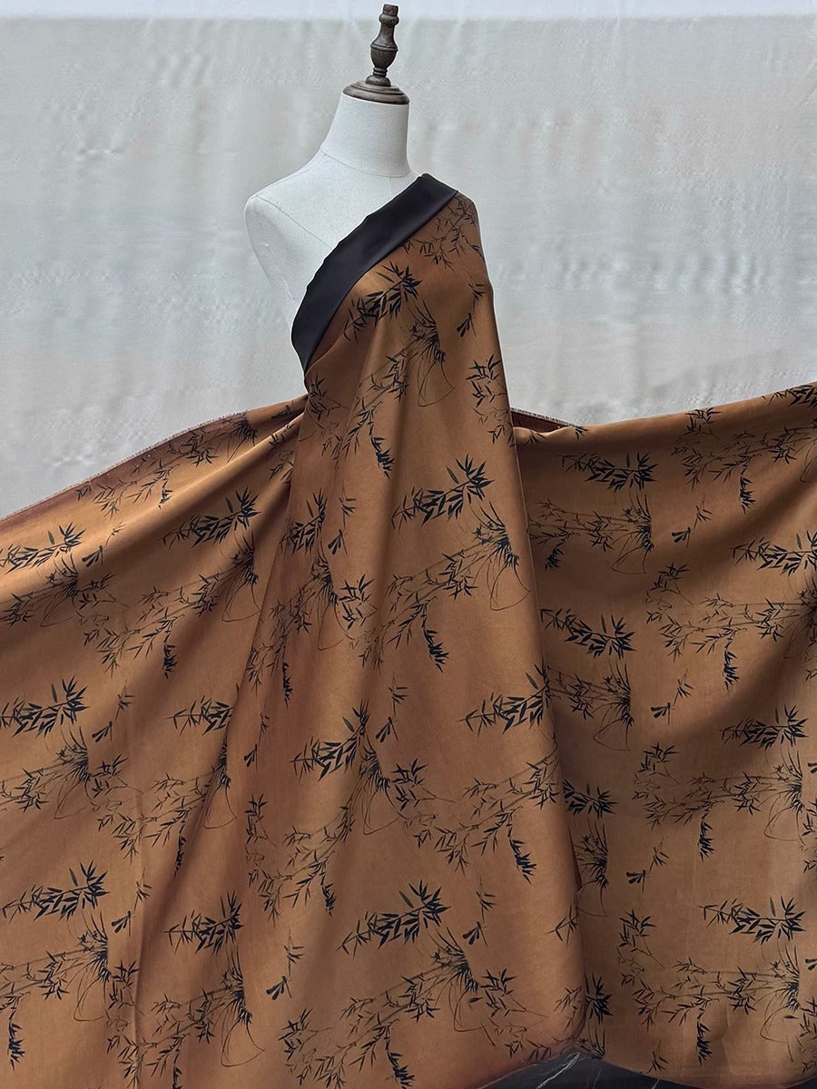 A mannequin wearing a brown and black floral print dress with a black trim, displayed against a plain background.