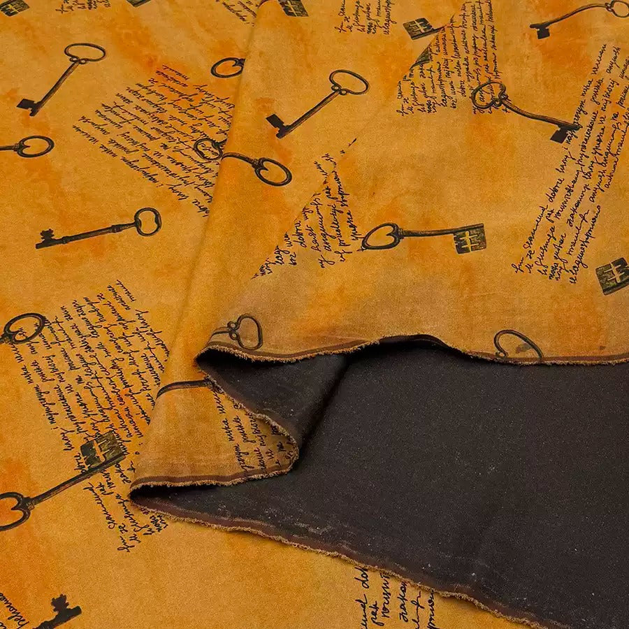 a close-up view of a fabric with a repeating pattern of black keys on a yellow background.