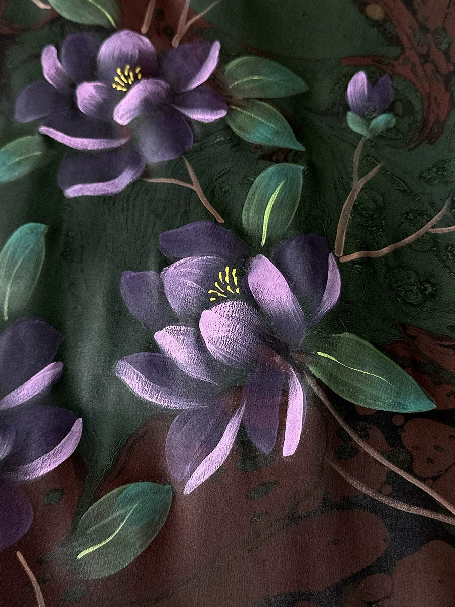 a close-up view of a painting of purple flowers with green leaves against a dark background.