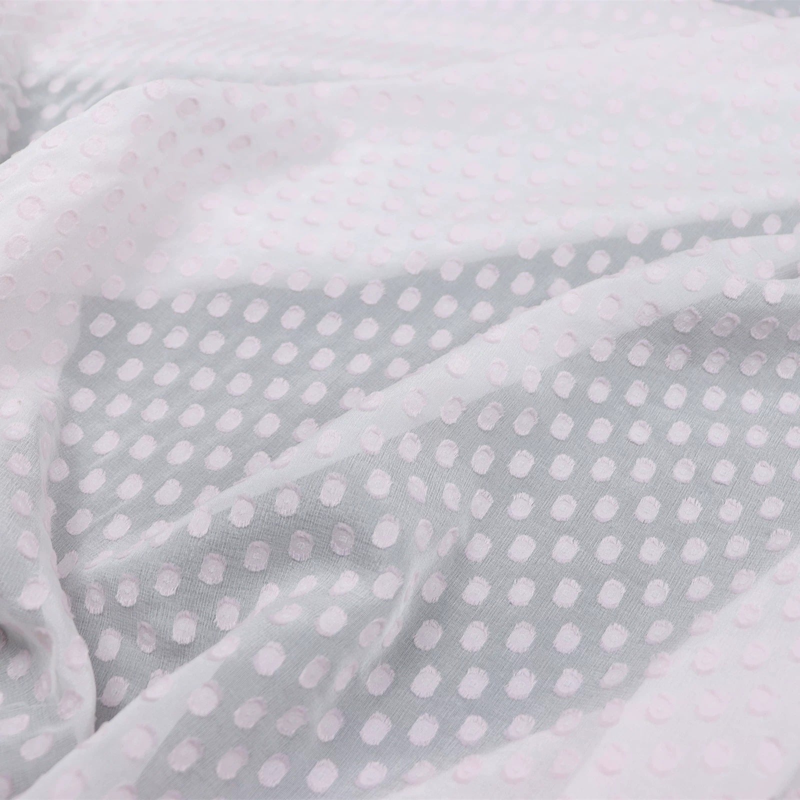 a close-up view of a fabric with a pattern of small white dots or circles, creating a textured and visually interesting surface.