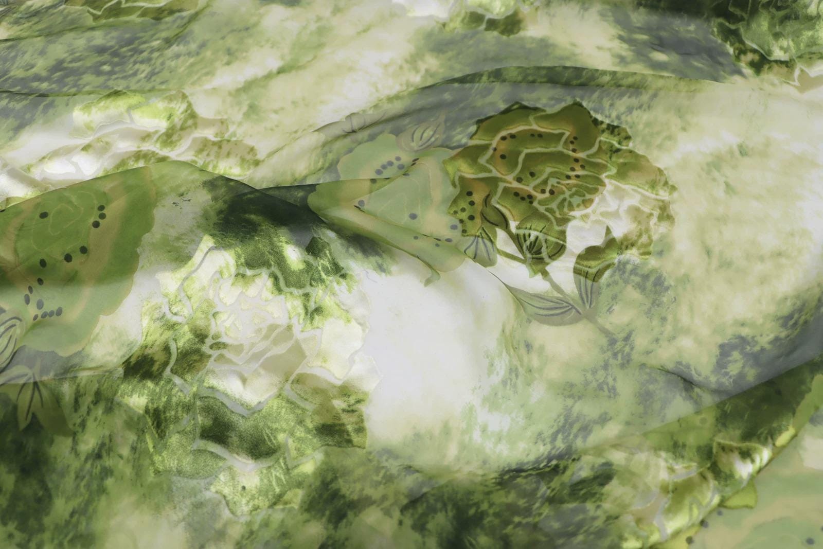 The image is a close-up of a fabric with a green and white floral pattern.