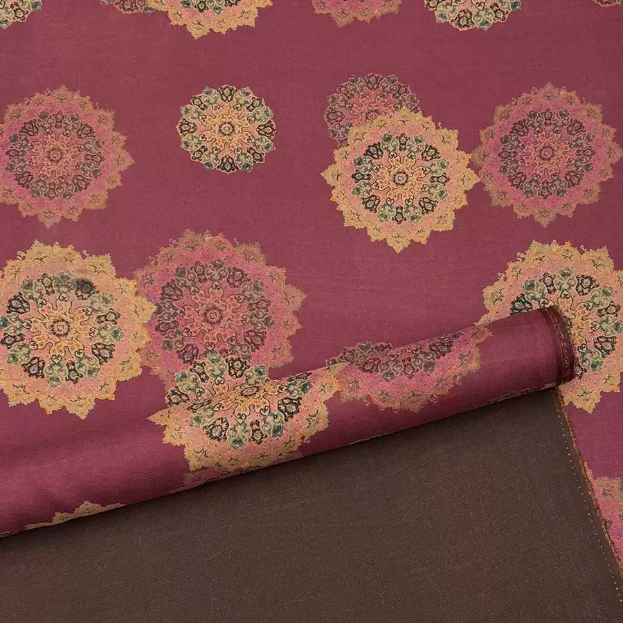 a close-up view of a fabric with a repeating pattern of colorful floral designs in shades of pink, green, and yellow. The fabric appears to be a piece of cloth or textile, with the pattern and colors creating a visually striking and intricate design.