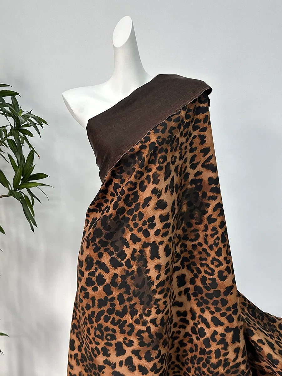 A mannequin wearing a brown and tan leopard print dress with a brown top draped over it.