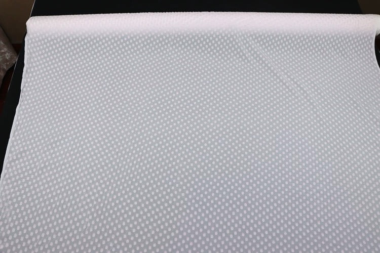 a close-up view of a white fabric with a polka dot pattern.