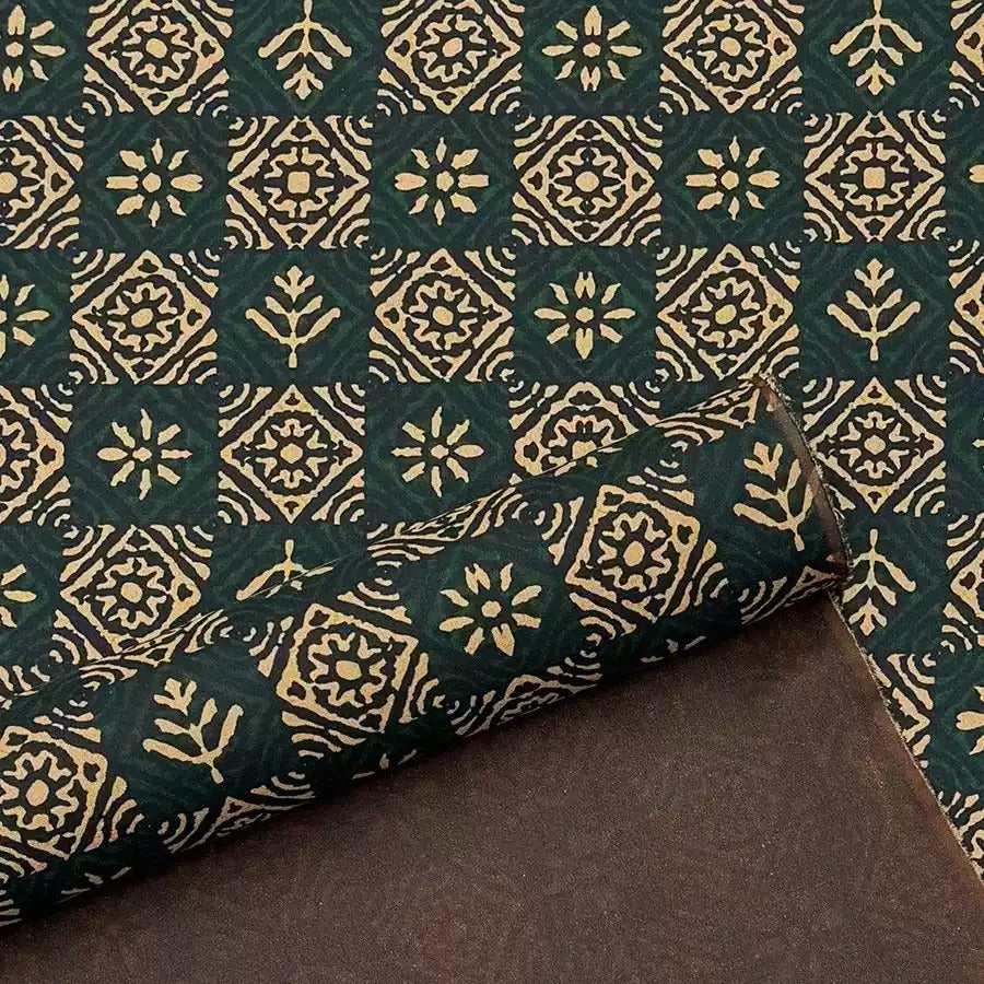 a close-up view of a patterned fabric with a repeating geometric design in shades of green and gold.