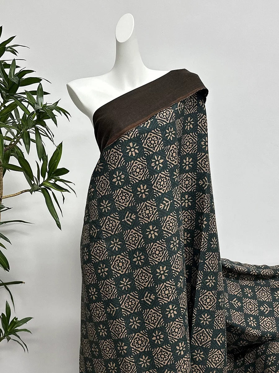A mannequin wearing a dress with a floral pattern in shades of green and brown.