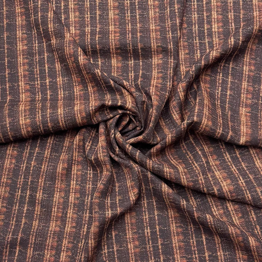 a close-up view of a fabric with a brown and orange striped pattern, folded and twisted in a criss-cross manner.