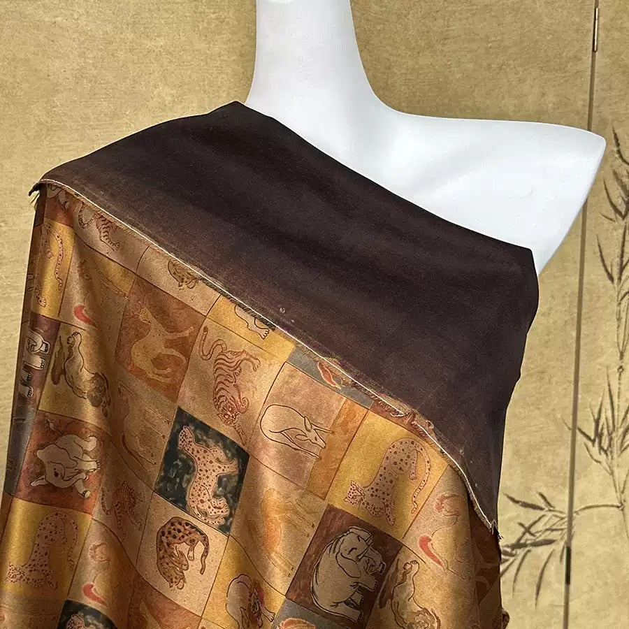 A mannequin wearing a brown and gold patterned shawl or wrap, with a dark brown fabric draped over the shoulders.