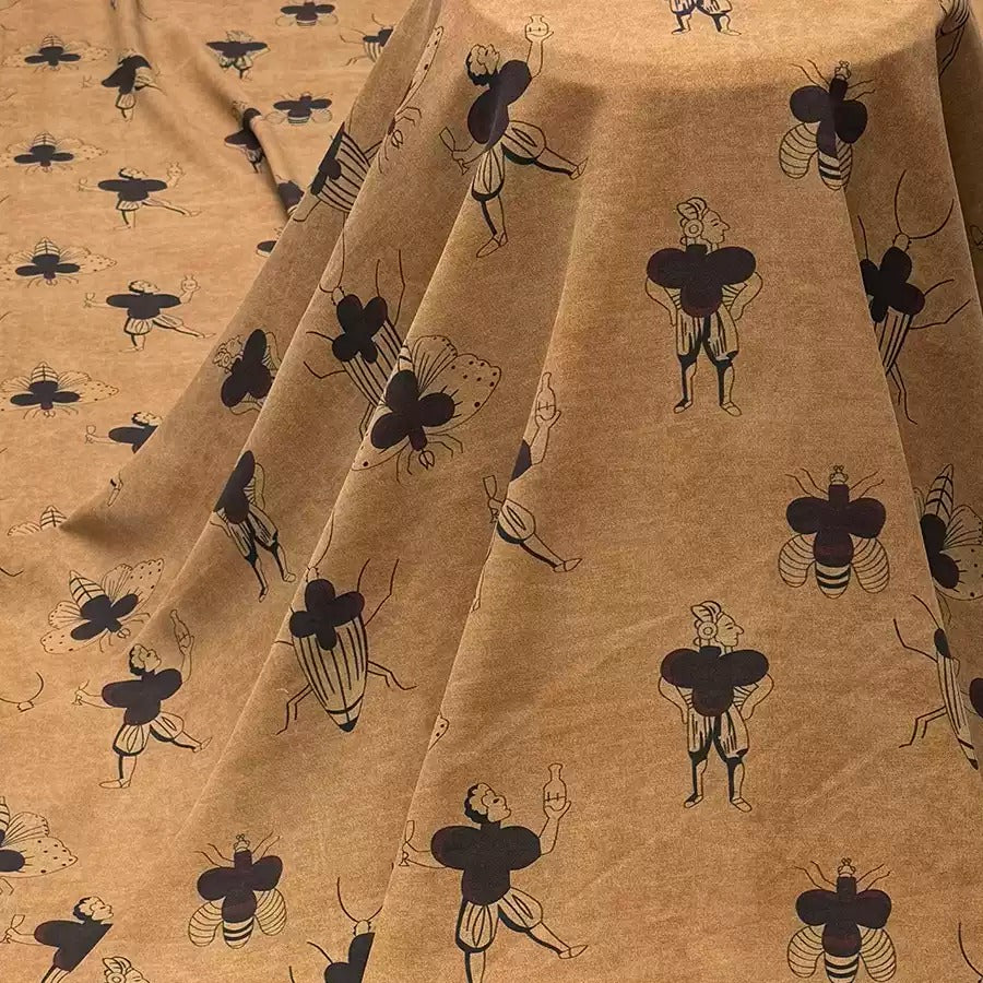 a fabric with a repeating pattern of stylized black and white figures, including insects and people, creating a visually striking and intricate design.